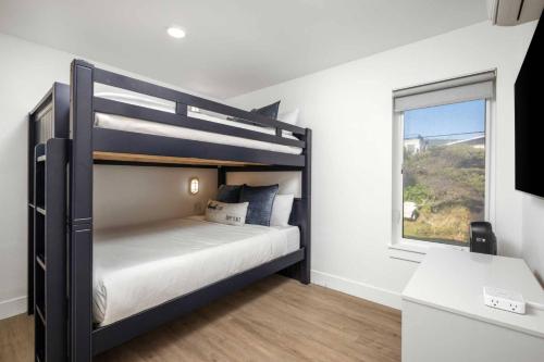 a bedroom with a bunk bed and a window at The Sandmark in Rockaway Beach