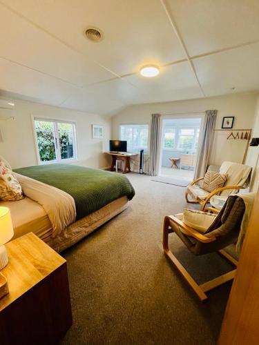 a bedroom with a bed and a couch and a desk at Saltwater Studio in Motueka