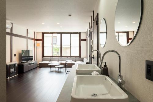 a bathroom with two sinks and a large mirror at J style villa Sapporo フルリフォーム 長期滞在にもオススメ マーケット近く in Sapporo