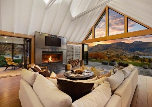 sala de estar con sofá grande y chimenea en Aroha Homestead Luxury Holiday Home by MajorDomo, en Arrowtown