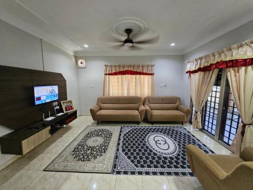 a living room with a couch and a tv at Teratak Abah in Seri Manjung