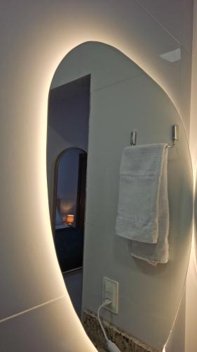a mirror in a bathroom with a towel at Flats Stúdio Serra Talhada in Serra Talhada