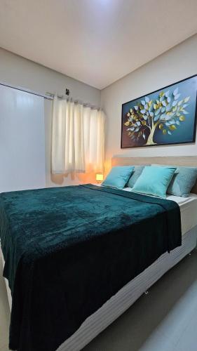 a bedroom with a large bed with blue pillows at Flats Stúdio Serra Talhada in Serra Talhada