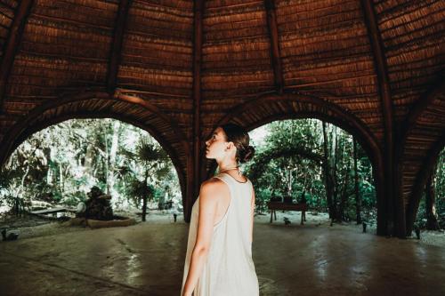 a woman in a white dress standing in a building at Pent House - Santuario Apartments in Chemuyil