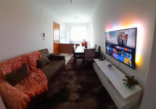 ein Wohnzimmer mit Couch und Flachbildfernseher in der Unterkunft Aconchego AMS Próx ao Aeroporto Internacional CWB in São José dos Pinhais