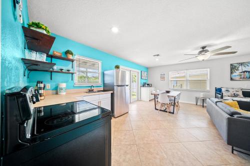 a kitchen and living room with a blue wall at Sea Breeze Retreat in Fort Pierce