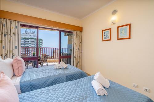 2 bedden in een slaapkamer met een balkon bij Sea Top Flat II in Portimão