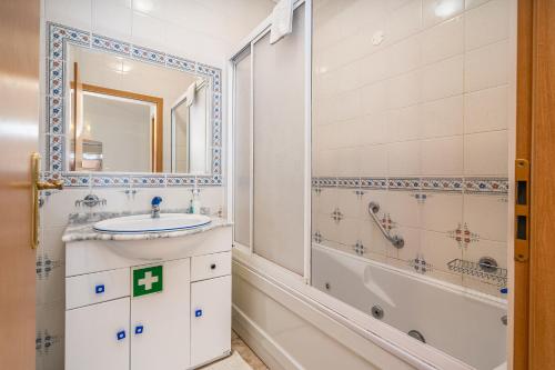 een badkamer met een wastafel en een bad bij Sea Top Flat II in Portimão