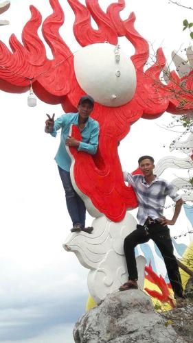 two men are sitting on top of a statue at Huỳnh van phương in Kon Rung (1)