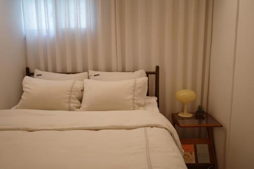 a bedroom with a bed with white pillows at Stay Hosa in Suwon