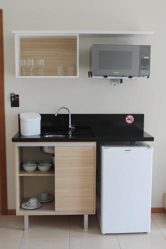 a kitchen with a sink and a microwave at Varadero Palace Hotel in Florianópolis