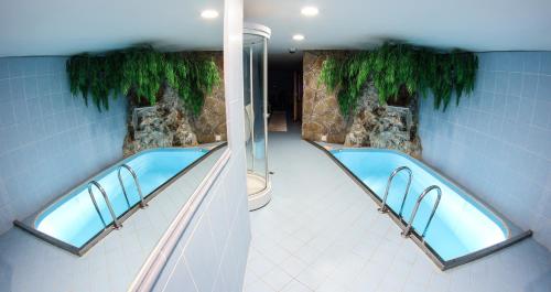 a bathroom with two hot tubs at Hotel Šomka in Drienica