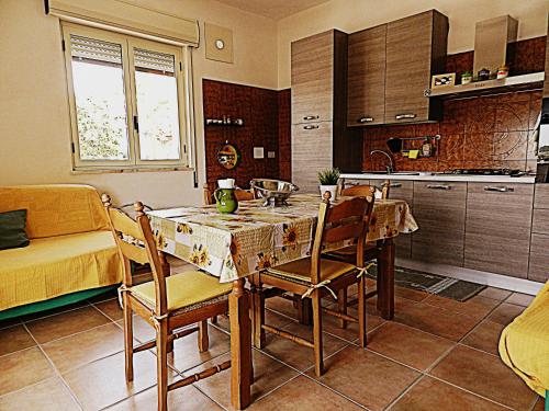 ノート・マリーナにあるAppartamento Don Ninoのキッチン(テーブル、椅子付)