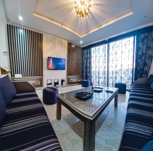 a living room with a couch and a table at Elegant Luxurious Apartment with Parking and Pool in Agadir