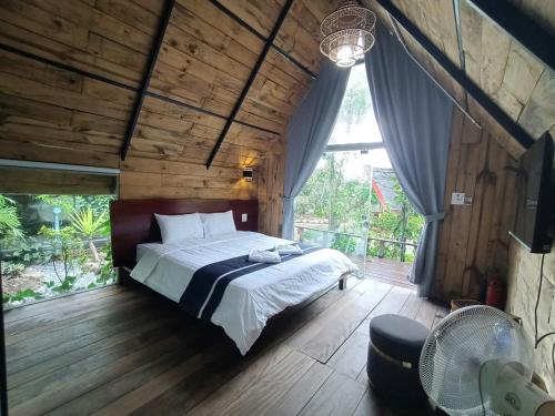 a bedroom with a bed and a large window at Bungalow HTC tuần châu in Ha Long