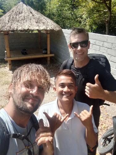 a group of three men posing for a picture at Rasta Homestay Ekas Bay in Pulau Gilkaliantan