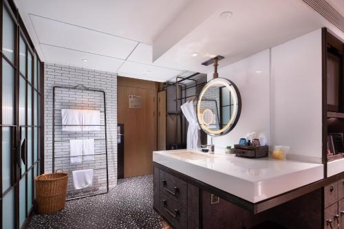 un bagno con lavandino e specchio di Lingshui Xiangshui Bay Summer Surfing Resort a Lingshui