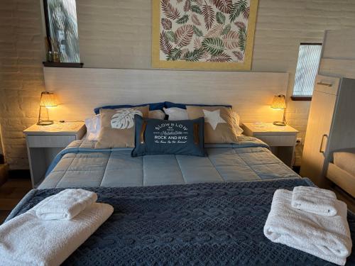 a bedroom with a bed with two towels on it at Apart Los Cerrillos in Balcarce