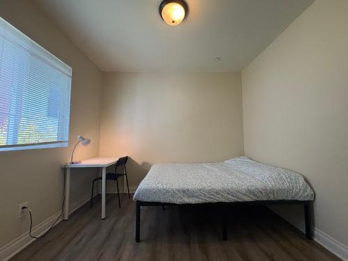 a bedroom with a bed and a table and a window at Blue Private Room near BMO Stadium USC and K-Town in Los Angeles
