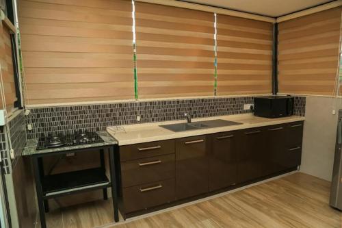 a kitchen with wooden cabinets and a sink at Mount Star Villa in Sita Eliya