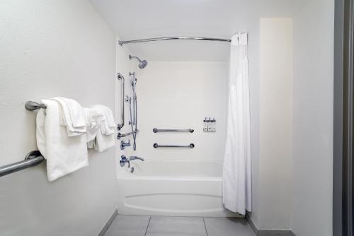 a white bathroom with a shower with towels at Holiday Inn Express & Suites Walterboro by IHG in Walterboro