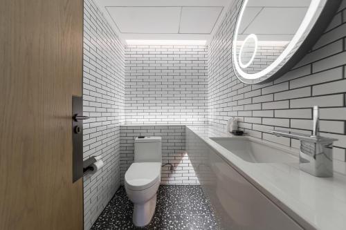 a bathroom with a toilet and a sink and a tub at Lingshui Xiangshui Bay Summer Surfing Resort in Lingshui