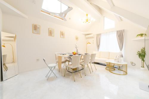 a white dining room with a table and chairs at Luxury Tokyo Stay I 120sqm 4LDK I Close to Shibuya & Shinjuku Area in Tokyo