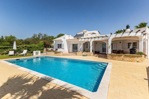 a swimming pool in front of a house at Villa Lucie vue mer avec piscine privée en Algarve.. in Faro