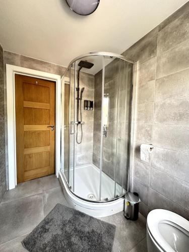 ein Badezimmer mit Dusche, Toilette und Waschbecken in der Unterkunft Modern Ground floor 2 Bed Room Apartment Work Leisure Free Parking in Woking