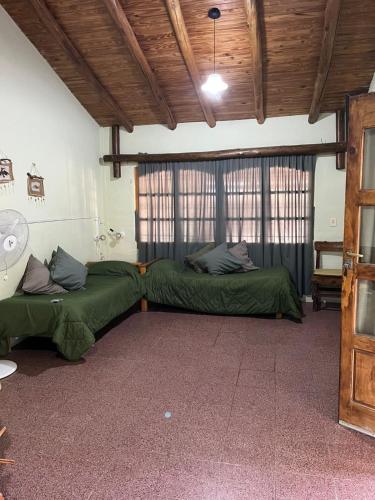 a room with two beds in a room with windows at Cabañas Nono Mario in San Rafael