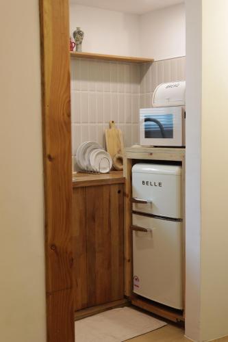 a small kitchen with a microwave and a refrigerator at Stay Hosa in Suwon