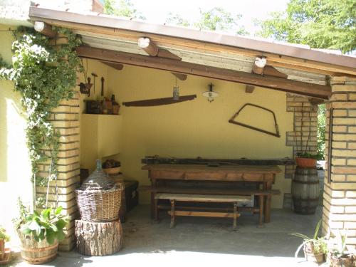 patio z drewnianą ławką i stołem w obiekcie Le Stagioni w mieście Loreto Aprutino