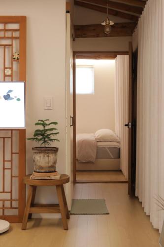 a room with a plant on a table and a bedroom at Stay Hosa in Suwon