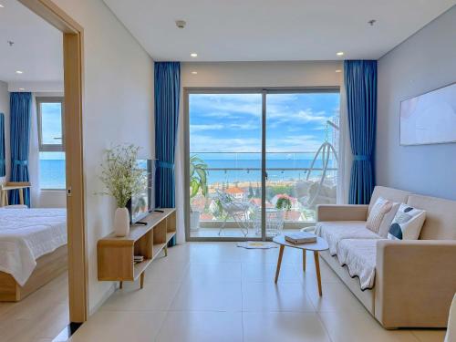 a living room with a couch and a view of the ocean at CĂN HỘ NGHĨ DƯỠNG CAO CẤP THE SÓNG VŨNG TÀU Mt VƯƠNG in Vung Tau