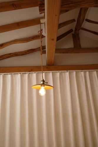 a light hanging from a chain in front of a curtain at Stay Hosa in Suwon