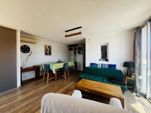 un salon avec un canapé vert et une table dans l'établissement Appartement T2 à Argelès avec terrasse, barbecue, parking et climatisation - FR-1-309-393, à Argelès-sur-Mer