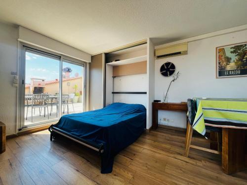 une chambre avec un lit, une table et un balcon dans l'établissement Appartement T2 à Argelès avec terrasse, barbecue, parking et climatisation - FR-1-309-393, à Argelès-sur-Mer