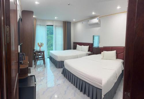 a hotel room with two beds and a television at Dũng Thảo Hostel in Bắc Hà
