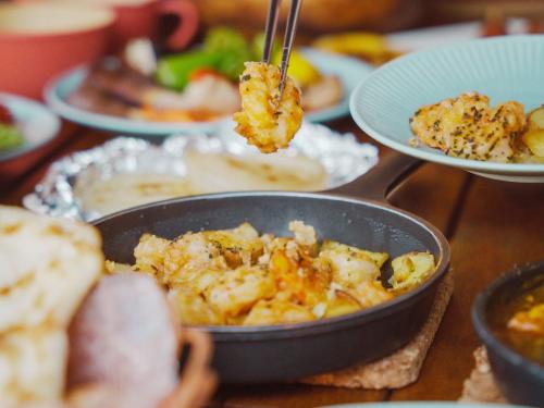 a table with a pan of food and plates of food at GLAMPING GATE 奈良 in Nara