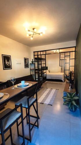 a living room with a table and chairs and a bed at Studio 61- No Coração de Curvelo in Curvelo