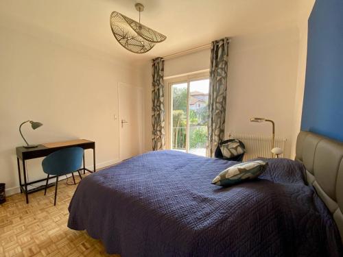 ein Schlafzimmer mit Bett, Schreibtisch und Fenster in der Unterkunft Maison rénovée à Cambo, 2 ch, jardin, parking, WiFi - FR-1-495-154 in Cambo-les-Bains