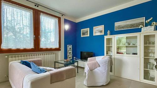 - un salon avec des murs bleus et un canapé blanc dans l'établissement Domus Felix Ferienhaus, à San Felice del Benaco