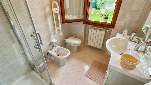 une salle de bain avec toilettes, lavabo et douche dans l'établissement Domus Felix Ferienhaus, à San Felice del Benaco