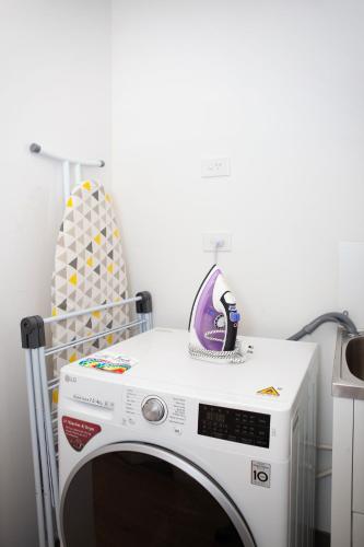 a white washing machine in a room with a chair at Artel Apartments Brunswick in Melbourne