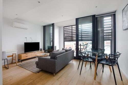 a living room with a couch and a glass table at Artel Apartments Brunswick in Melbourne