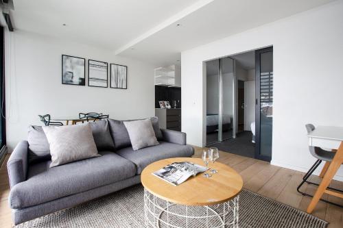 a living room with a couch and a table at Artel Apartments Brunswick in Melbourne