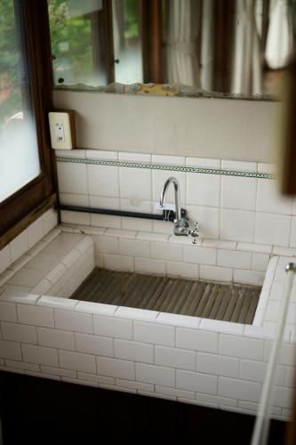 a bathroom with a bath tub with a sink at そわか楼 in Fukuyama