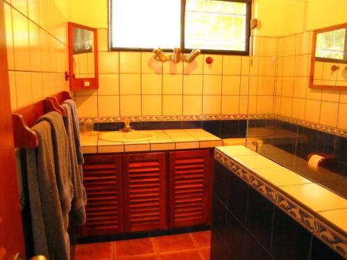 a bathroom with a sink and a tub at Casa Amarilla in Esterillos