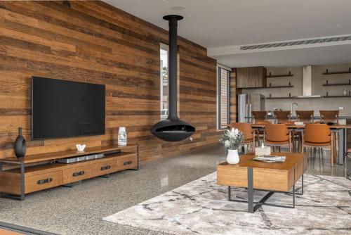 a living room with a television on a wooden wall at Luxury Two Bedroom with Vineyard Views The Reserve Retreat U10 in Mount View