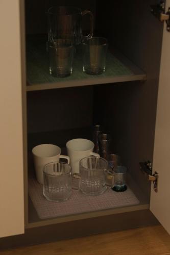 a shelf with bowls and other dishes in a cabinet at Stay Hosa in Suwon
